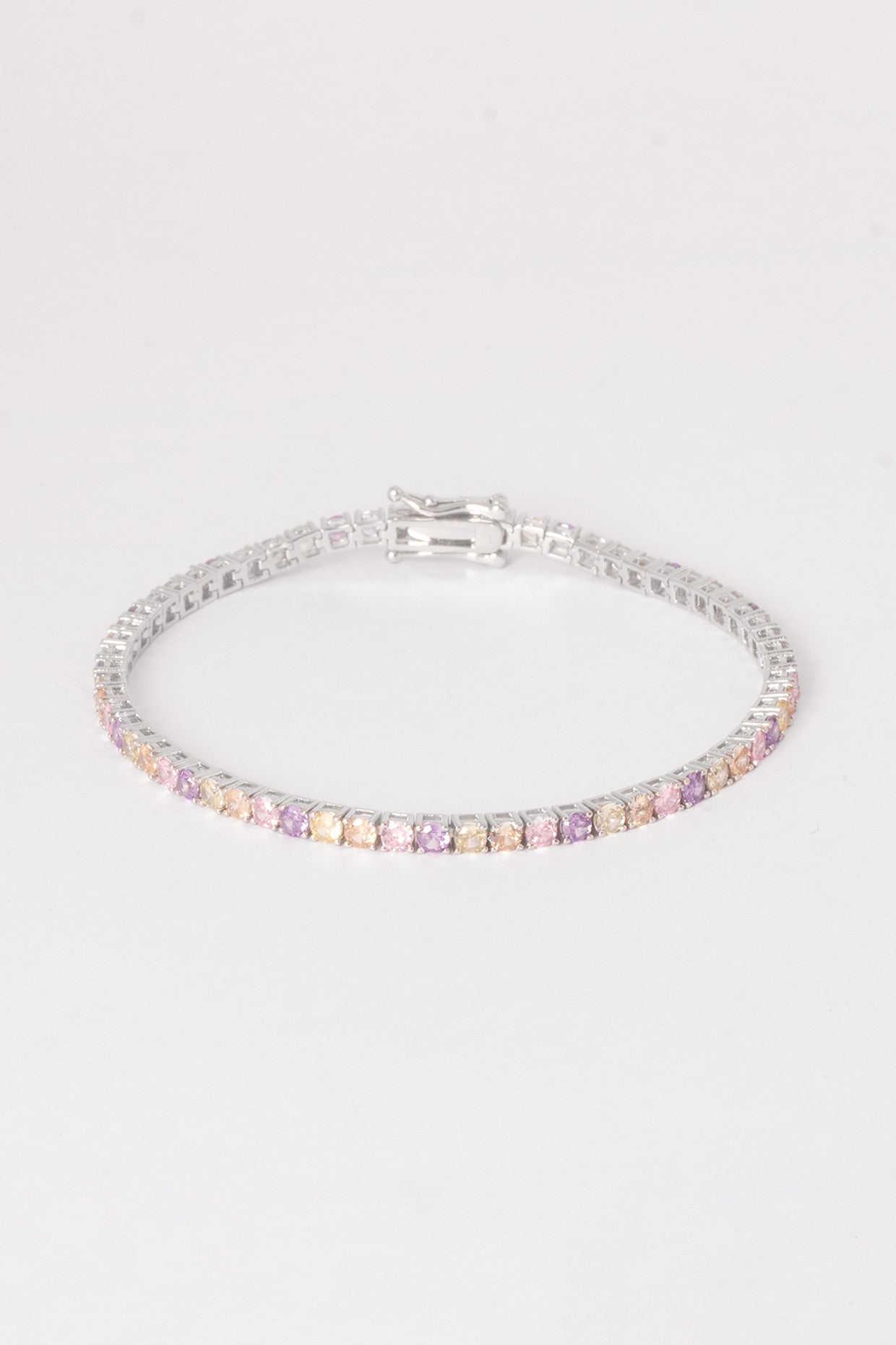 Silver bracelet with multicolored stones on a light gray background